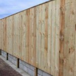 Wooden fence on retaining wall